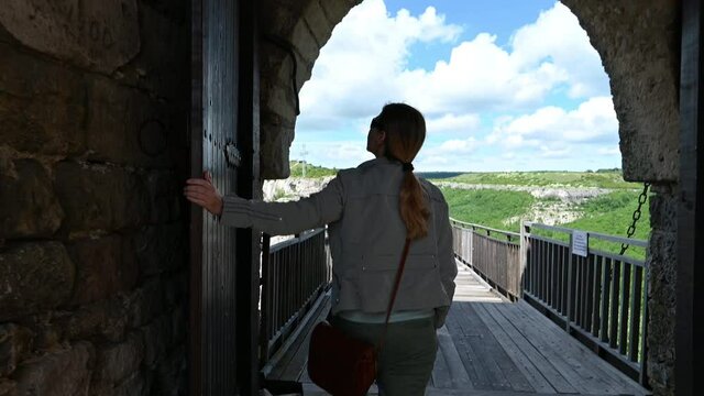 Video with a woman walks around the ruins of the old medieval fortress Ovech near Provadia, Bulgaria and enjoys the view from above.