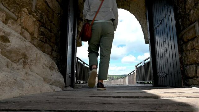 Video with a woman walks around the ruins of the old medieval fortress Ovech near Provadia, Bulgaria and enjoys the view from above. Low-angle view.