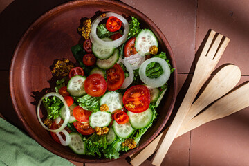 Vegetarian salad with cucumber, tomato and spinach in a plate