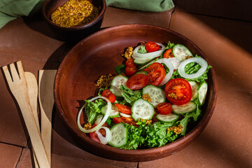 Vegetarian salad with cucumber, tomato and spinach in a plate