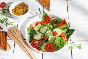 Vegetarian salad with cucumber, tomato and spinach in a plate