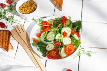 Vegetarian salad with cucumber, tomato and spinach in a plate