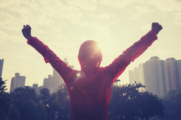 Focused woman open arms to sunrise city