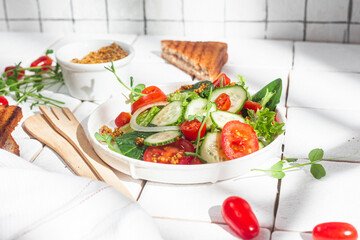 Vegetarian salad with cucumber, tomato and spinach in a plate