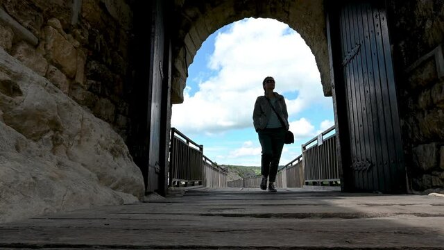 Video with a woman walks around the ruins of the old medieval fortress Ovech near Provadia, Bulgaria and enjoys the view from above. Low-angle view.