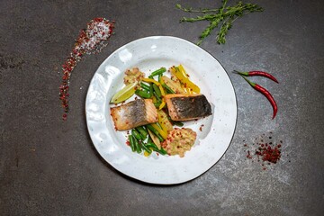 Baked salmon in Mexican style. Salmon baked in olive oil, string beans, corn cobs, bell pepper. top view