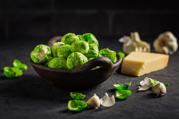 Raw Brussel sprouts with salt and Parmesan cheese in bowl