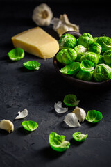 Raw Brussel sprouts with salt and Parmesan cheese in bowl