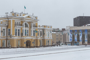Naklejka premium Uralsk, Kazakhstan, 6.01.2022 - Barbed wire in front of the regional akimat, barbed wire around the perimeter of the state building during the state of emergency in the country, rallies in Kazakh