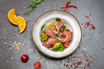 Salad with Parma ham, baked pepper and pesto sauce. Parma ham, mixed salad, baked pepper, cherry confit, orange pesto sauce, pine nuts