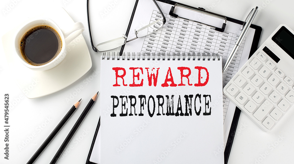 Poster reward performance text on the paper with calculator, notepad, coffee ,pen with graph