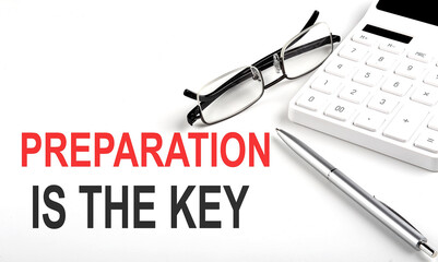 PREPARATION IS THE KEY Concept. Calculator,pen and glasses on the white background