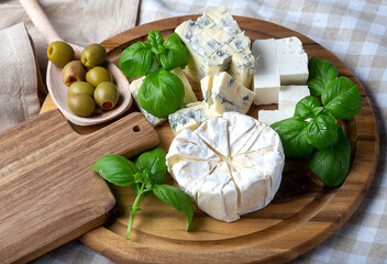 different types of cheesse on the wooden cutting board