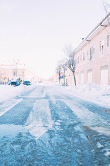 Street full of ice after a heavy snowfall with cars buried under the snow. Winter season.