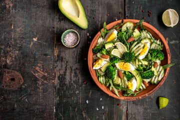 Green salad with avocado, cucumber, broccoli and egg. Healthy organic vegan salat with sliced avocado. Delicious breakfast or snack, Clean eating, dieting, vegan food concept. top view