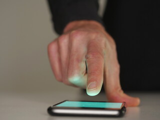 Close-up of man's finger touching smartphone