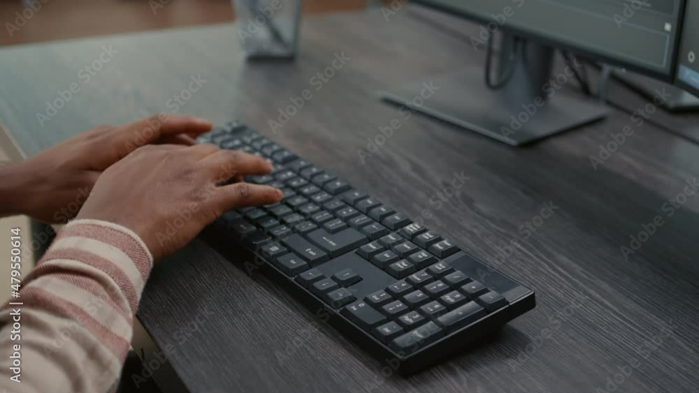 Poster closeup of african american programer hands typing code on keyboard while looking at computer screen