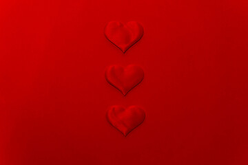 Three hearts in the center on a red background with copy space for valentine's day.