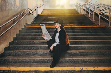 retro portrait of a young girl with a newspaper in her hands. woman standing in a tunnel underpass.