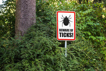 Tick insect warning sign in nature forest. Danger of Lyme disease, Borrelia and Meningitis.