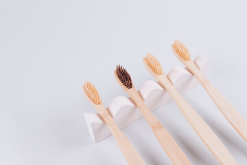 Top view on natural bamboo toothbrushes on biege plaster mold against gray background with copy space. Sustainable lifestyle, zero waste home. Selective focus. Mockup image
