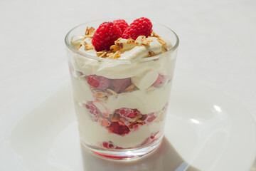 Traditional Scottish Cranachan dessert with toasted oats, fresh raspberries, cream and whisky in a glass.