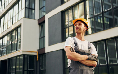 Modern exterior. Young man working in uniform at construction at daytime