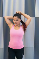 Latin Woman in sports clothes fixing her hair during training