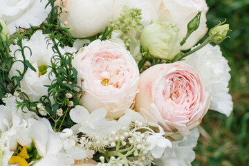 Delicate pink peony-shaped roses close-up in a bouquet for the bride. Holiday gift