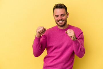 Young caucasian man isolated on yellow background dancing and having fun.