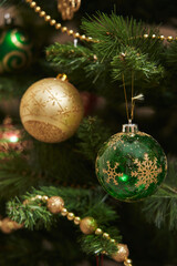 beautiful gold and green ball on a decorated christmas tree
