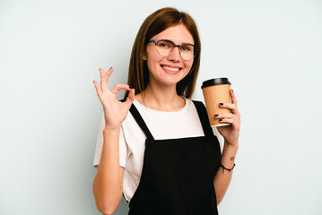 Restaurant waiter woman holding a take away coffee isolated on blue background cheerful and...