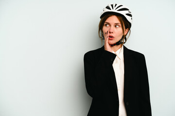 Young business English woman isolated on blue background is saying a secret hot braking news and looking aside