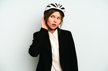 Young business English woman isolated on blue background trying to listening a gossip.
