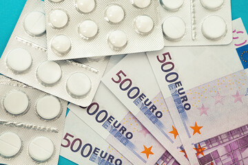 Money pills. Medicine pills on euro bills on a blue background. Covid-19 coronavirus pills are in euro money. The concept of insurance medicine, insurance, high cost, high cost of drugs.