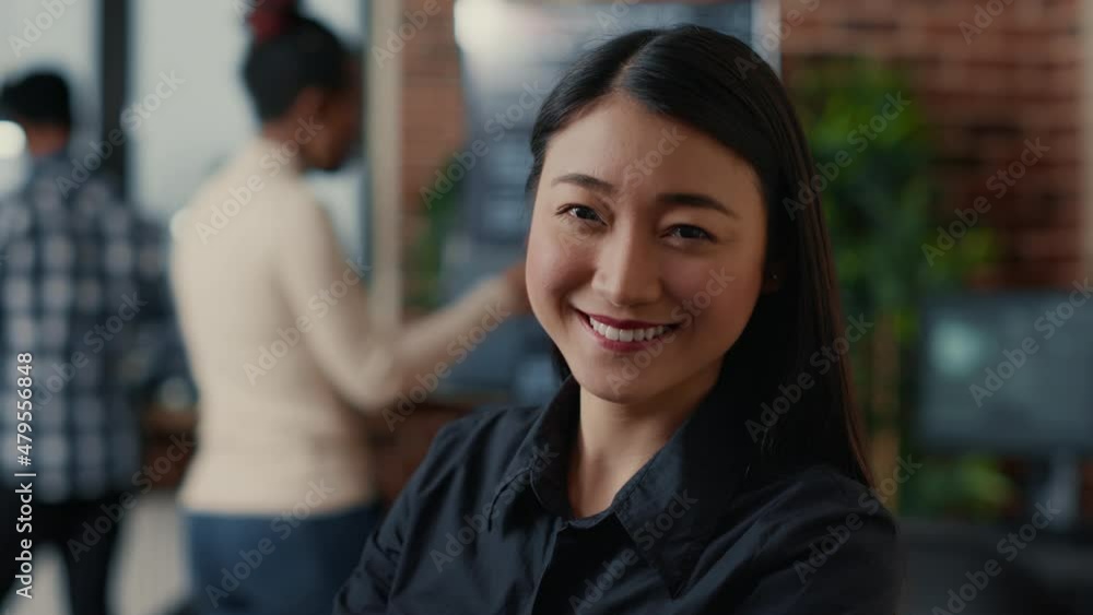 Poster portrait of smiling asian software developer looking at camera in cloud computing development agency