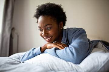 Close up smiling African American relaxing in bed