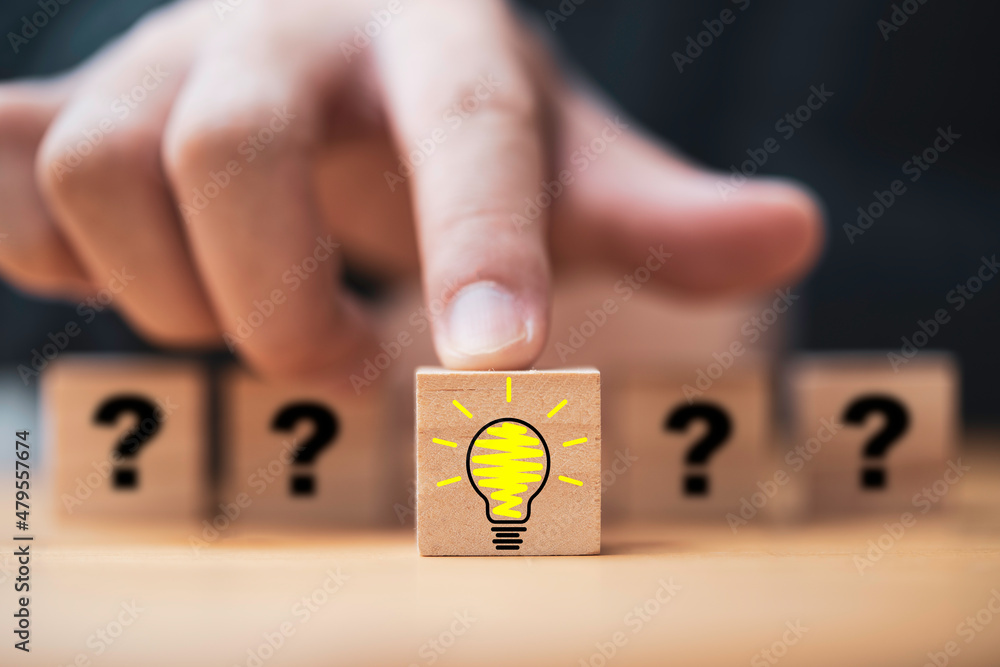 Poster hand pushing lightbulb drawing which print screen on wooden cube block among human and question mark
