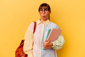 Fototapeta premium Young student Argentinian woman isolated on yellow background shrugs shoulders and open eyes confused.