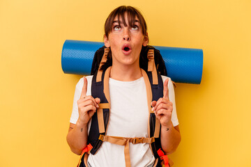 Young Argentinian hiker woman isolated on yellow background pointing upside with opened mouth.