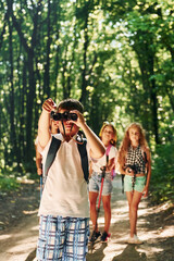 Beautiful nature. Kids strolling in the forest with travel equipment