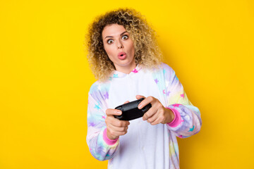 Fototapeta premium Portrait of attractive amazed addicted wavy-haired girl in pajama playing video game pout lips isolated over bright yellow color background