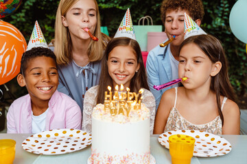 White happy girl in party cone celebrating birthday with her friends