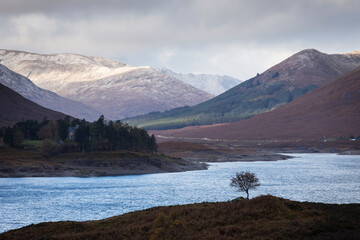 Autumn landscape in Highlands, Scotland, United Kingdom. Beautiful mountains with snow in background.