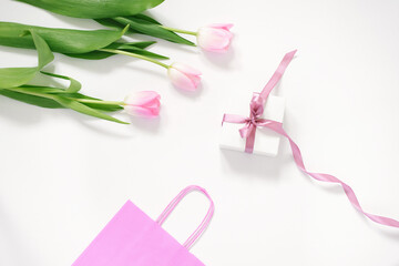A bouquet of pink tulips, a gift box with a pink bow and a pink bag on a white background. Concept of Valentine's Day, Mother's Day, Birthday and Spring