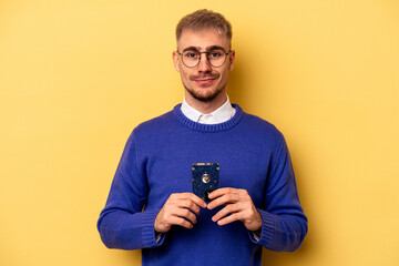 Young computer man isolated on yellow background