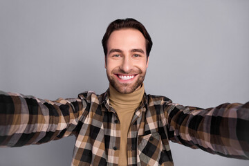 Fototapeta premium Photo of charming pretty man wear plaid shirt smiling recording self video isolated grey color background