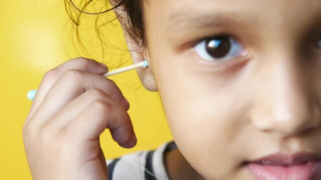 child girl using ear cotton bar close up 