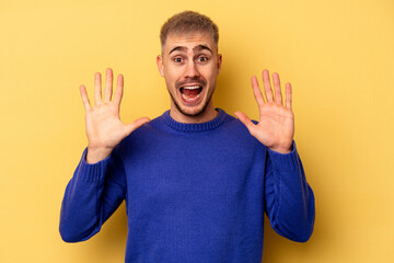 Young caucasian man isolated on yellow background receiving a pleasant surprise, excited and raising hands.