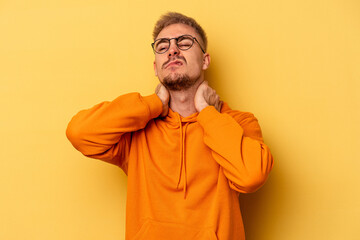 Young caucasian man isolated on yellow background suffering neck pain due to sedentary lifestyle.